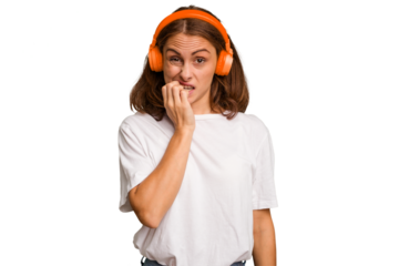 Young caucasian woman listening to music with headphones isolated biting fingernails, nervous and very anxious.