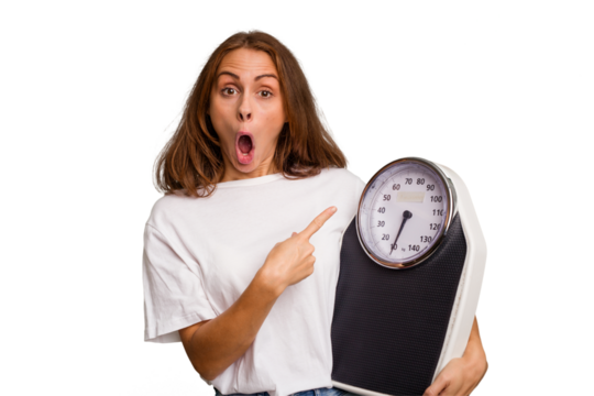 Young caucasian woman holding a scale and measure tape isolated pointing to the side