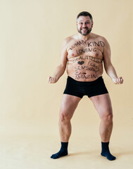 man posing for a male edition body positive beauty set. Shirtless guy wearing boxers underwear in...
