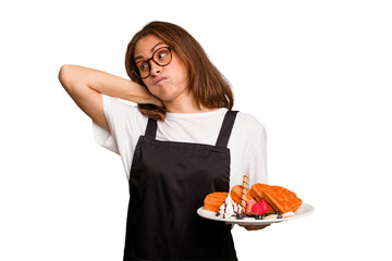 Young caucasian woman holding a waffles dish isolated touching back of head, thinking and making a choice.