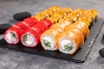 Sushi set. Philadelphia roll, california, unagi with fresh ingredients on black background. Sushi menu. Japanese asian food.