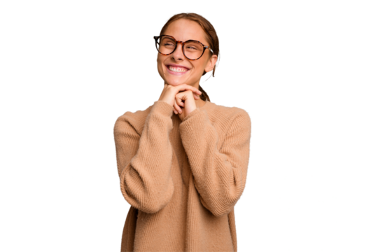 Young caucasian woman isolated keeps hands under chin, is looking happily aside.