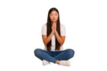 Young asian woman sitting on the floor cutout isolated making up plan in mind, setting up an idea.