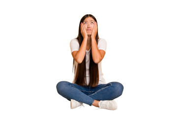 Young asian woman sitting on the floor cutout isolated whining and crying disconsolately.