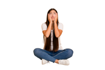 Young asian woman sitting on the floor cutout isolated whining and crying disconsolately.