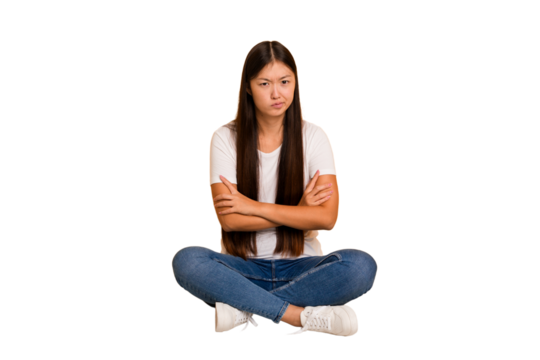 Young asian woman sitting on the floor cutout isolated unhappy looking in camera with sarcastic expression.