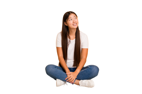 Young asian woman sitting on the floor cutout isolated relaxed and happy laughing, neck stretched showing teeth.