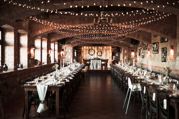 Beautiful wedding room with wedding table with food, flowers anddrinks, decorations,lights 