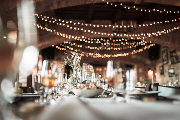 Fototapeta na wymiar Beautiful wedding room with wedding table with food, flowers anddrinks, decorations,lights 