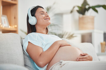 Music, headphones and pregnant woman relax on sofa in home living room streaming radio or podcast. Pregnancy, meditation and female from Canada on couch listening to song, audio or sound in house.