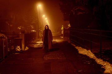 smiling young woman walking along the ALLEY of the night city