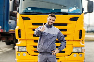 A happy driver is giving thumbs up for efficient and on time shipping while standing in front of...