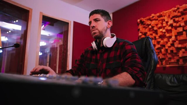 Sound studio engineer sad and overworked working hard in his job frustrated and unhappy by a problem having headache and stress. High quality 4k footage