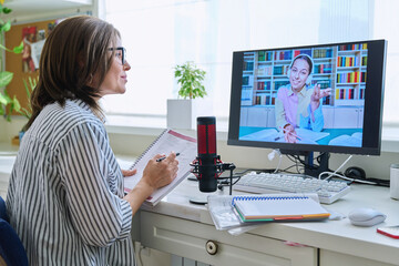 Obraz na płótnie Canvas Mature woman talking online with teenage girl using video call