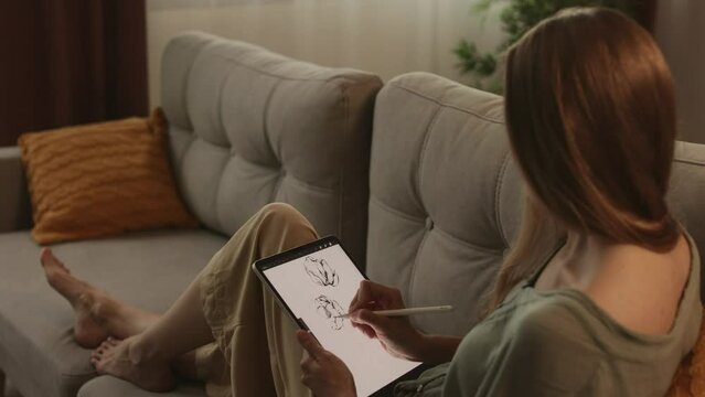 Artist or designer making new project, drawing on a graphic tablet with pencil, close-up on a screen.