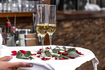 Close-up of hands holding a tray with two glasses of champagne, Waiter hands holding tray with two glasses of champagne. Unrecognizable person holding tray with two glasses of champagne