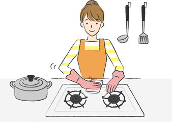 キッチンでコンロを掃除する女性