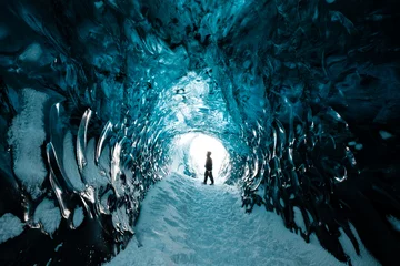 Fototapeten Person is standing in beautiful ice cave in Vatnajkull glacier Iceland in the winter © Dominik