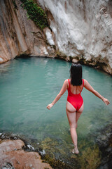 woman in red swimsuit Dimosari waterfall at Lefkada island Greece