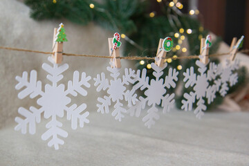 Christmas garland of snowflakes on wooden clothespins
