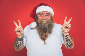 Funny crazy santa claus with tattoo having fun on a red colored background