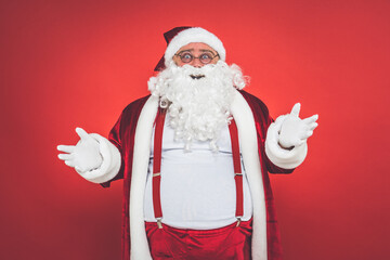 Funny crazy santa claus having fun on a red colored background