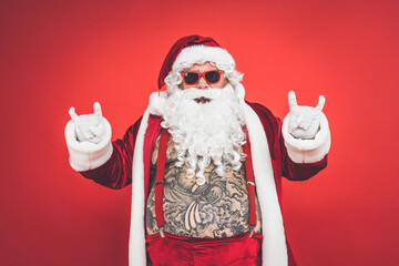 Funny crazy santa claus with tattoo having fun on a red colored background