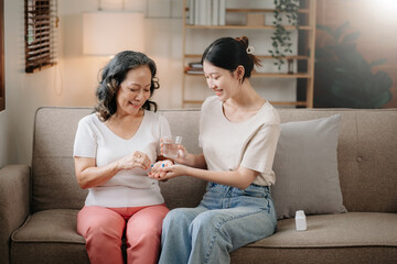 Asian woman taking care and giving a glass of water and taken daily medicine or vitamin...