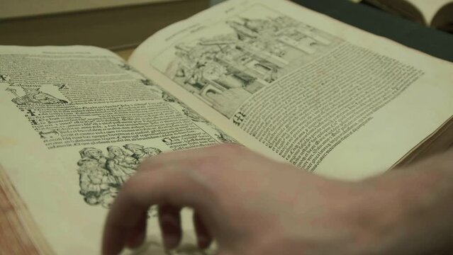 Flipping pages through old medieval book, Nuremberg Chronicle, text and artwork