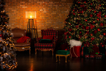 The Christmas tree is located in the loft-style room. Under the tree there are a lot of red and...