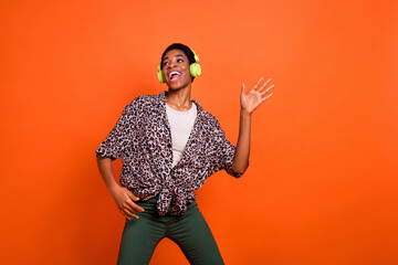 Photo of excited cheerful person have fun enjoy new favorite single song isolated on orange color background