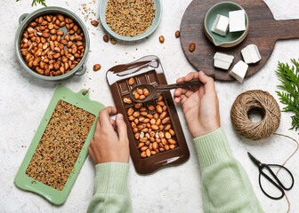 Step 1. Child filling the chocolate bar form with peanuts. Children education concept. Help people...
