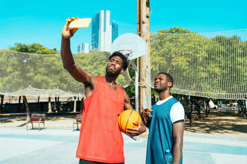 Young basketball players training at the court. Cinematic look image of friends practicing shots and slam dunks in an urban court © oneinchpunch