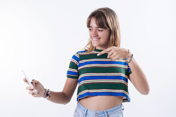 young woman with wide smile holding blank screen mobile phone and pointing index finger