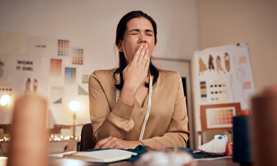 Tired fashion designer, woman and yawn while working at night in creative office, textile studio or...