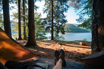 View from the tourist hammock. From the first person. The lake and Carpathian mountains are in the background. Beautiful morning. Travel and vacation. Tereblya, Ukraine