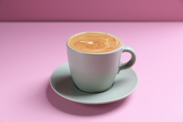 hot cappuccino with latte art isolated in pink background