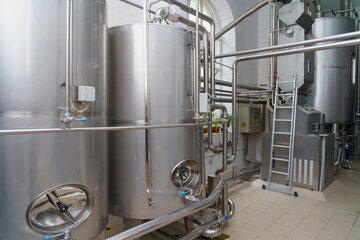 A stainless steel vat in the food industry at a brewery in the process of brewing beer. Background