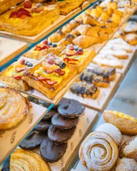 Tuinposter Display of delicious sweets on the counter of a bakery © VíctorRdez