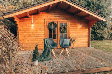 Nice holiday home in Sweden or Germany with outdoor seating. Small wooden house with chairs outside...