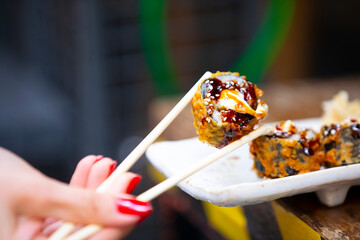 Eating amazing sushi with chopsticks.