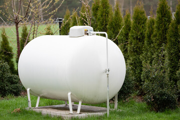 Propane gas tank for home heating. Gas supply for heating the building. - obrazy, fototapety, plakaty