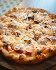 pizza with cheese, bacon and jam on a wooden base