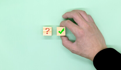Hand making a choice between two cubes with Yes and No on neutral background.