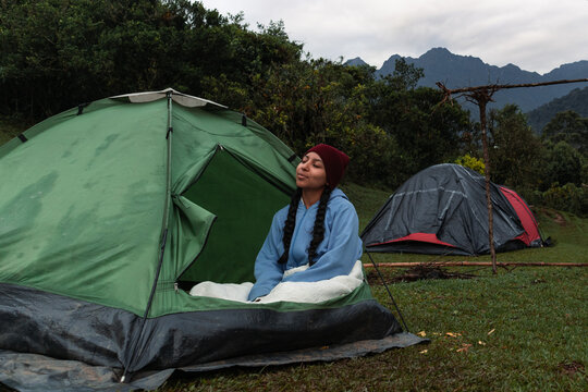 Mujer relaj&aacute;ndose en camping con paisaje monta&ntilde;oso y clima fr&iacute;o en el Parque Nacional Farallones de Cali, Colombia.