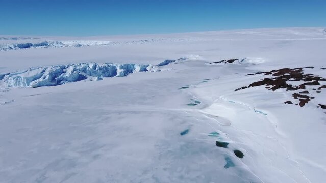 Snow covered antarctic surface aerial view flight. Desert white land of snow and ice drone shot. Frozen south pole. 