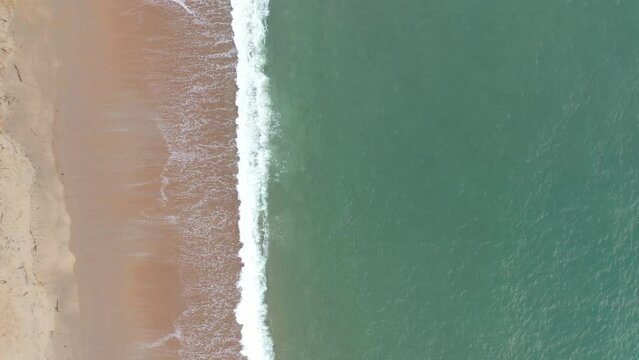 drone shot over waves crashing on a sandy beach coast Basque province of Labourd France