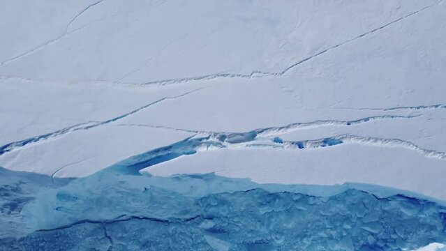 Snow covered antarctic surface aerial view flight. Desert white land of snow and ice drone shot. Frozen south pole. 