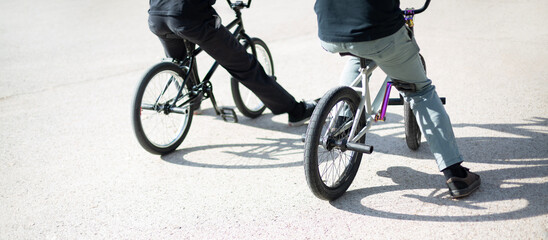 Back view of two unrecognizable people with bmx bikes. Urban outdoor lifestyle concept.