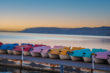 sunset over the lake, colorful lake bikes. pedalo.